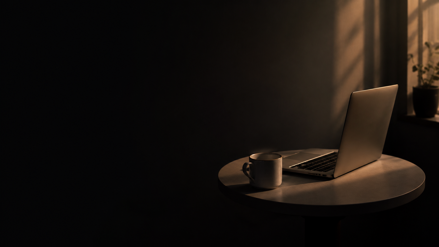 A quiet founder workspace with a laptop and coffee in warm evening light